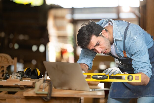 Foto ein zimmermann arbeitet in seiner werkstatt an einem laptop in einer holzbearbeitungsfabrik