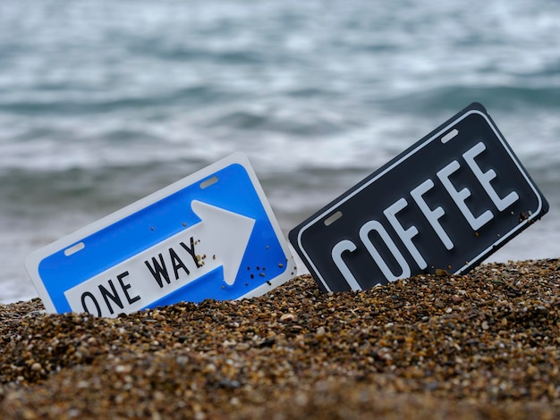 Einbahnstraße und Kaffeeschild am Strand