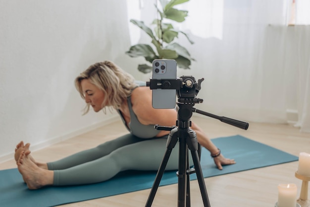 Eine 50-jährige Frau macht zu Hause Online-Yoga