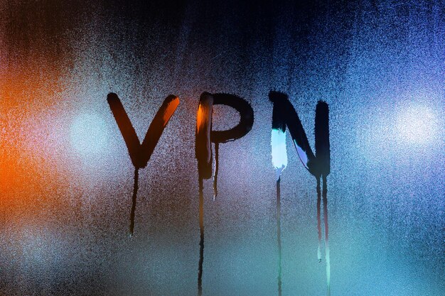 Eine Abkürzung VPN Virtual Private Network, die mit dem Finger auf nächtliches nasses Glas gezeichnet wurde