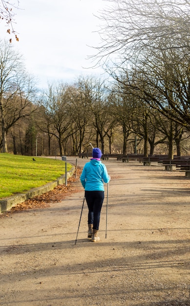 Eine ältere Frau übt Nordic Walking.