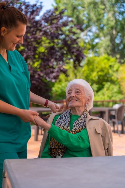 Foto eine ältere oder reife frau mit der krankenschwester im garten eines pflegeheims in einem moment der liebe und zuneigung