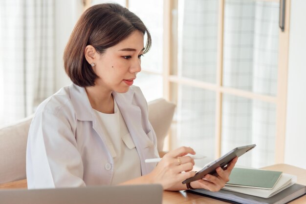 Foto eine ärztin analysiert in der praxis mit einem tablet die symptome einer patientin
