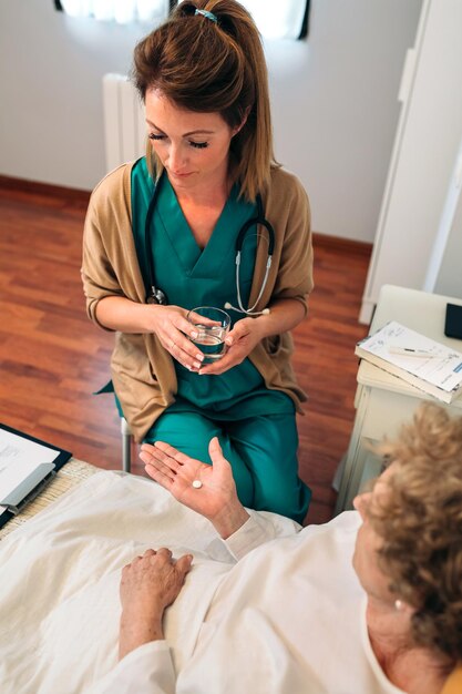 Foto eine ärztin untersucht einen älteren patienten im krankenhausbett