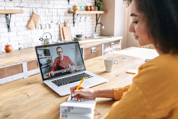 Eine afrikanische Frau benutzt einen Laptop für ein Video-Meeting