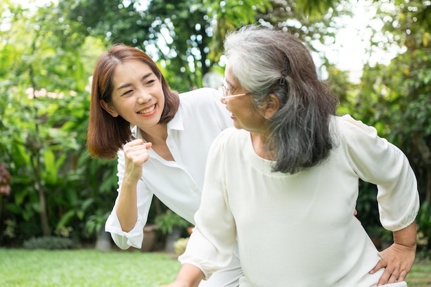 Eine alte ältere asiatische Frau und Übung im Hinterhof mit ihrer Tochter