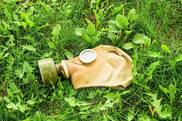 Eine alte Gasmaske liegt auf dem grünen Gras. Konzept des Umweltschutzes