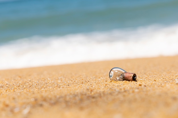 Eine alte Glühbirne ruht am Sandstrand