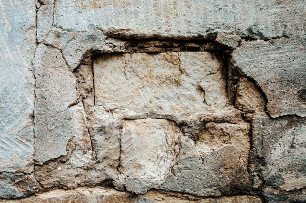 Eine alte Mauer, die einstürzt. Ziegel sichtbar.