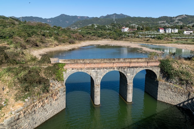 Eine alte Steinbrücke ist über dem Fluss