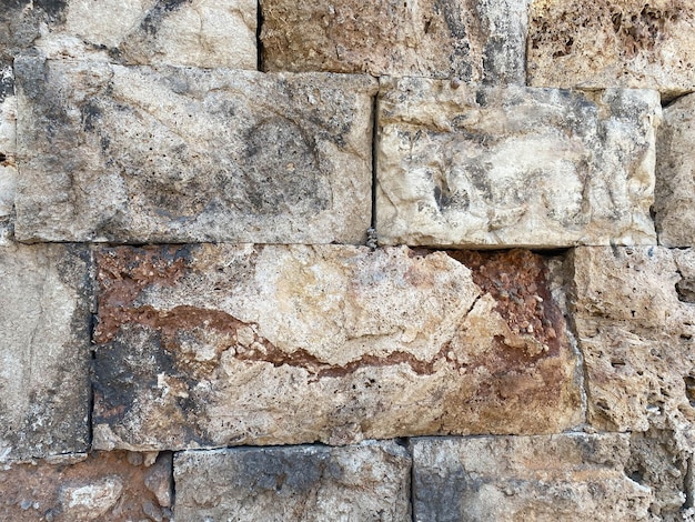 Eine alte Steinmauer aus Steinen und behauenen Blöcken