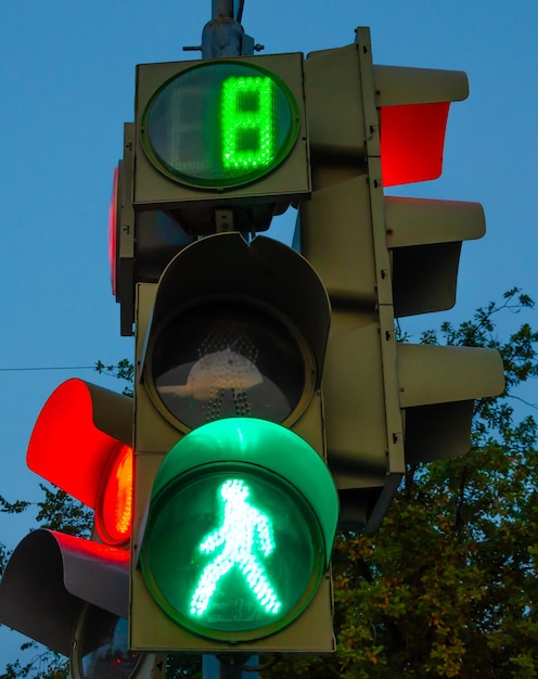 Foto eine ampel mit grünem licht und einer darauf gehenden person