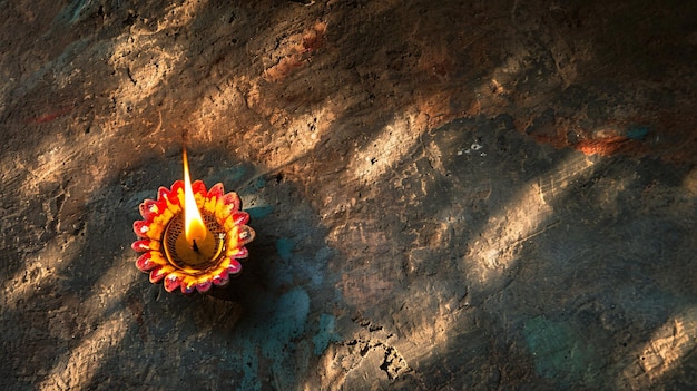 eine angezündete Kerze sitzt auf einem Felsen