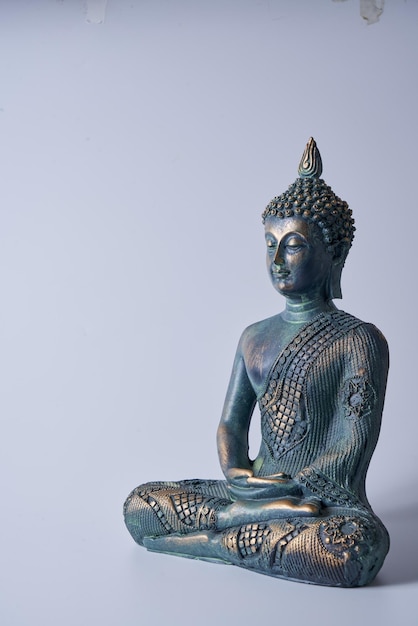 Eine antike Buddha-Statue aus Bronze auf einem weißen, isolierten Hintergrund.