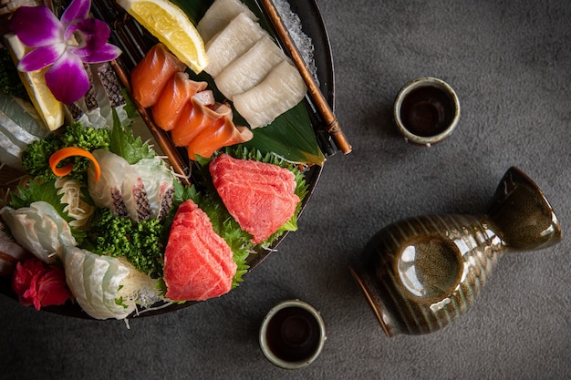 Eine Anzahl frischer Sashimi wird auf einen Teller gelegt Essstäbchen und Sojasauce werden platziert