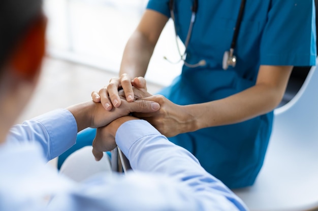 Eine Arztin gibt einem männlichen Patienten im Rollstuhl Ratschläge zur Physiotherapie