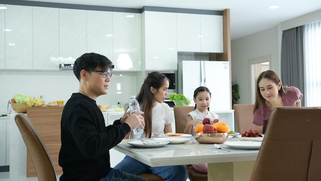 Eine asiatische Familie isst glücklich zusammen im Esszimmer des Hauses Frühstück