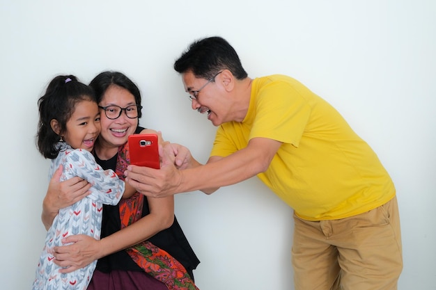 Eine asiatische Familie mit einer Tochter, die Zeit miteinander verbringt und alle glücklich lächeln