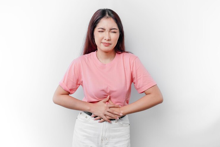 Eine asiatische Frau hat Hunger oder Menstruation oder Bauchschmerzen und berührt ihren Bauch