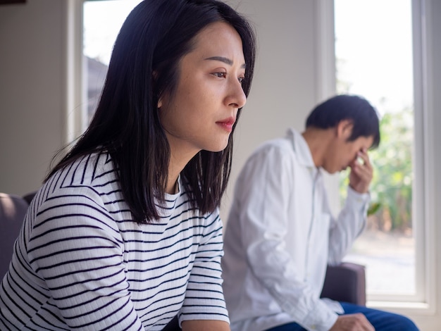 Eine asiatische Frau ist gestresst und besorgt über die Liebesprobleme zwischen ihrem Ehemann nach einem intensiven Streit. Konzepte von Liebenden mit familiären Problemen, Scheidung oder Streit oder Konflikten