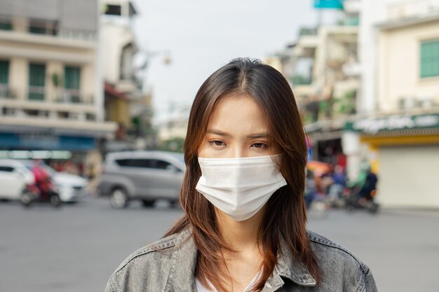 Eine asiatische Frau mit Maske, wenn sie auf der Straße geht