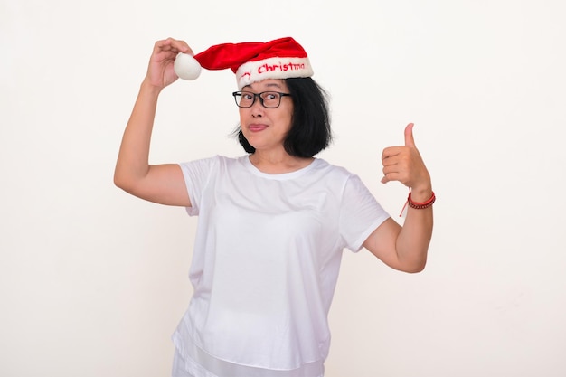 Eine asiatische Frau zeigt gerne ihren roten Weihnachtsmannshut, den sie zum Weihnachtsfest trägt