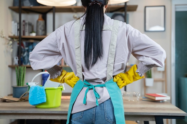 Foto eine asiatische junge frau, die zu hause einen holztisch putzt