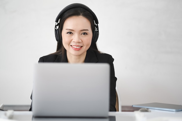 Eine asiatische Lehrerin mittleren Alters lebt online mit einem Laptop an der Universität