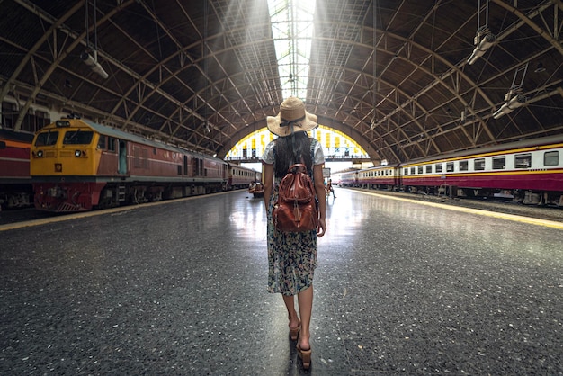 Eine asiatische Reisende reist und fährt mit dem Zug nach Chiang Mai in Thailand und geht zu Fuß in den Bahnhof von Bangkok, indem sie die Navigator-Anwendung auf ihrem Smartphone nutzt