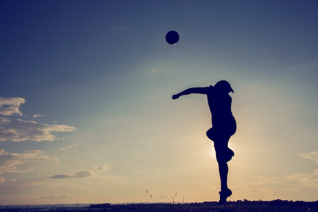 Foto eine asiatische überschrift des jungen mannes des fußballfußballspielers im schattenbild