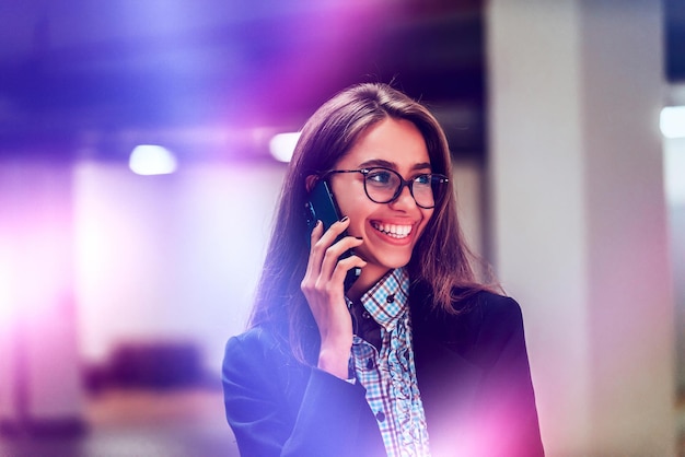 Eine attraktive Geschäftsfrau in Gläsern mit einem Smartphone Selective Focus Business Portrait