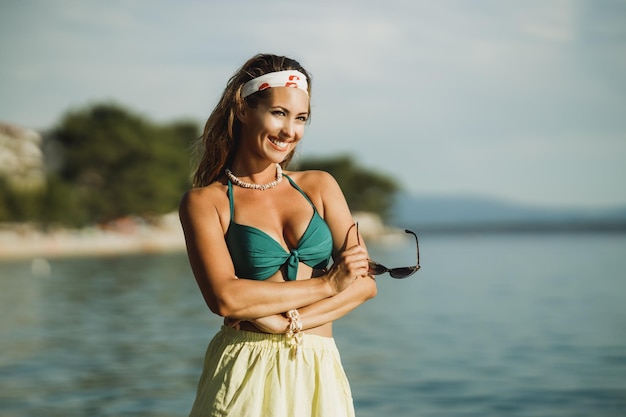 Eine attraktive junge Frau im Bikini hat Spaß am Strand und genießt einen Sommerurlaub.