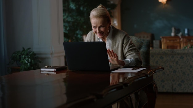 Eine aufgeregte ältere Frau erhält gute Nachrichten über einen Laptop in einem luxuriösen Zimmer. Eine glückliche Geschäftsfrau feiert ihren Erfolg neben einem Laptop zu Hause. Ein fröhlicher alter Mann arbeitet mit einem Laptops zu Hause.