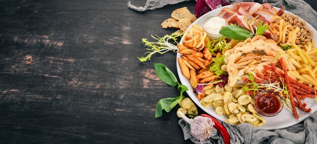 Eine Auswahl an Snacks für Bier Chips Wurstkäse Draufsicht auf Holzhintergrund Kopierbereich