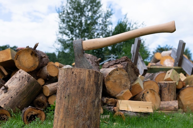 Eine Axt zum Hacken von Holz in der Nähe vor dem Hintergrund geschnittener Baumblöcke