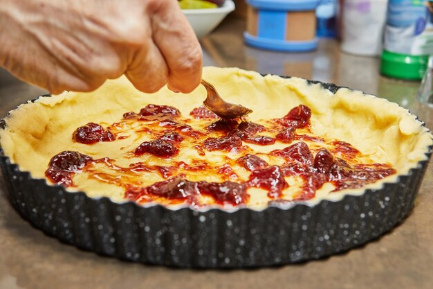 Eine Bäckerin bereitet einen köstlichen Pflaumenkuchen mit hausgemachter Marmelade vor