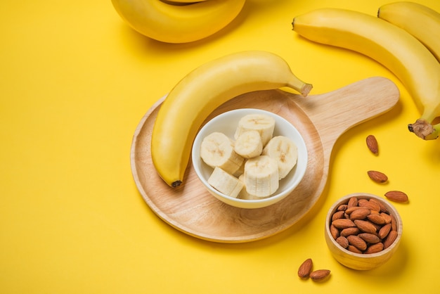 Eine Banane mit Mandeln auf gelbem Hintergrund.