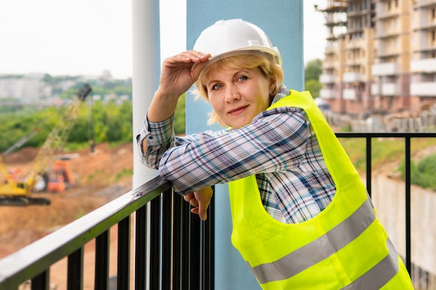 Eine Baumeisterin auf einer Baustelle inspiziert ein Gebäude