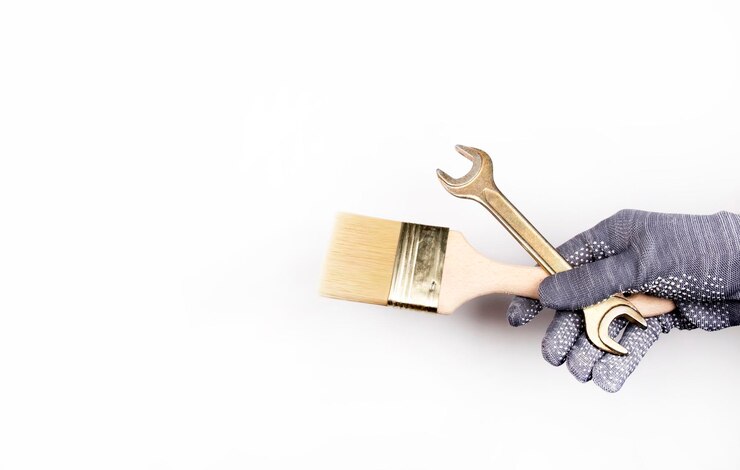 Foto eine behandschuhte hand hält eine bürste und einen schraubenschlüssel
