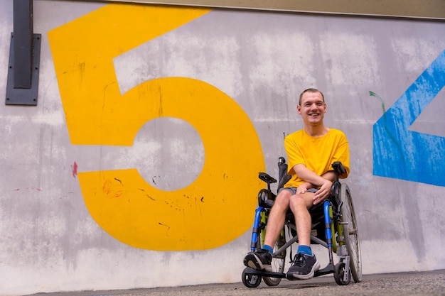 Eine behinderte Person in einem öffentlichen Park mit Nummern an der Wand im Rollstuhl