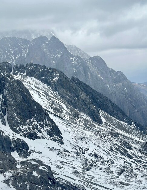 Eine Bergkette mit Schnee auf den Bergen und einem bewölkten Himmel