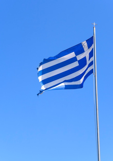 Eine blau-weiße griechische Flagge weht vor einem blauen Himmel