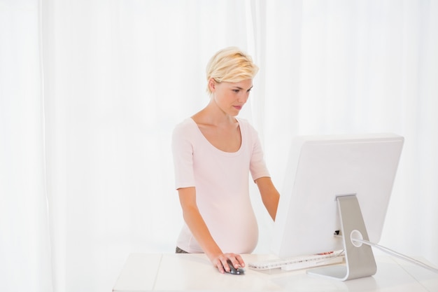 Eine blonde schwangere mit Computer