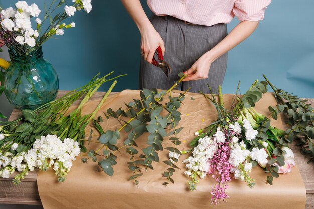 eine Blumenhändlerin macht einen Blumenstrauß in einem Blumenladen