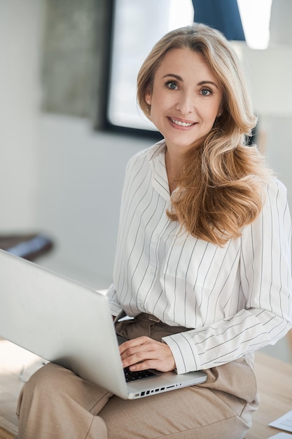 Eine bnlonde hübsche Frau, die im Büro arbeitet