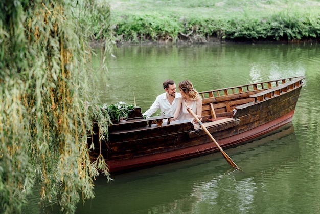 Eine Bootsfahrt für einen Mann und ein Mädchen entlang der mit wilden Weiden bewachsenen Kanäle und Buchten des Flusses