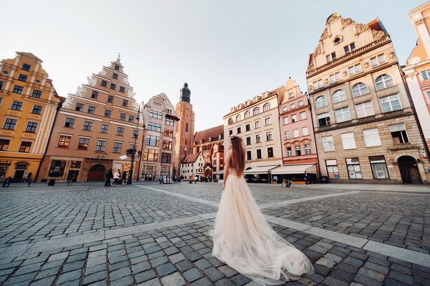 Eine Braut in einem Hochzeitskleid mit langen Haaren in der Altstadt von Breslau. Hochzeitsfoto-Shooting im Zentrum einer antiken Stadt in Polen. Breslau, Polen.