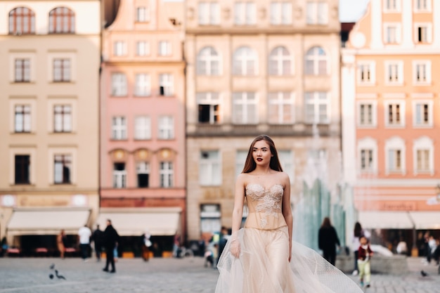 Eine Braut in einem Hochzeitskleid mit langen Haaren in der Altstadt von Breslau. Hochzeitsfoto-Shooting im Zentrum einer antiken Stadt in Polen. Breslau, Polen.