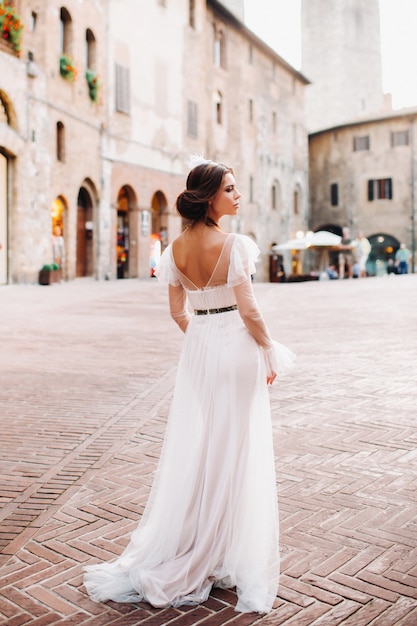 Eine Braut in einem weißen Kleid in der Altstadt von San Gimignano