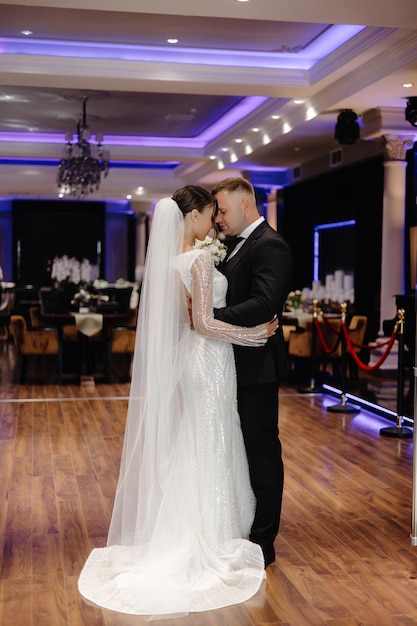 eine Braut und ein Bräutigam küssen sich auf einem Holzboden